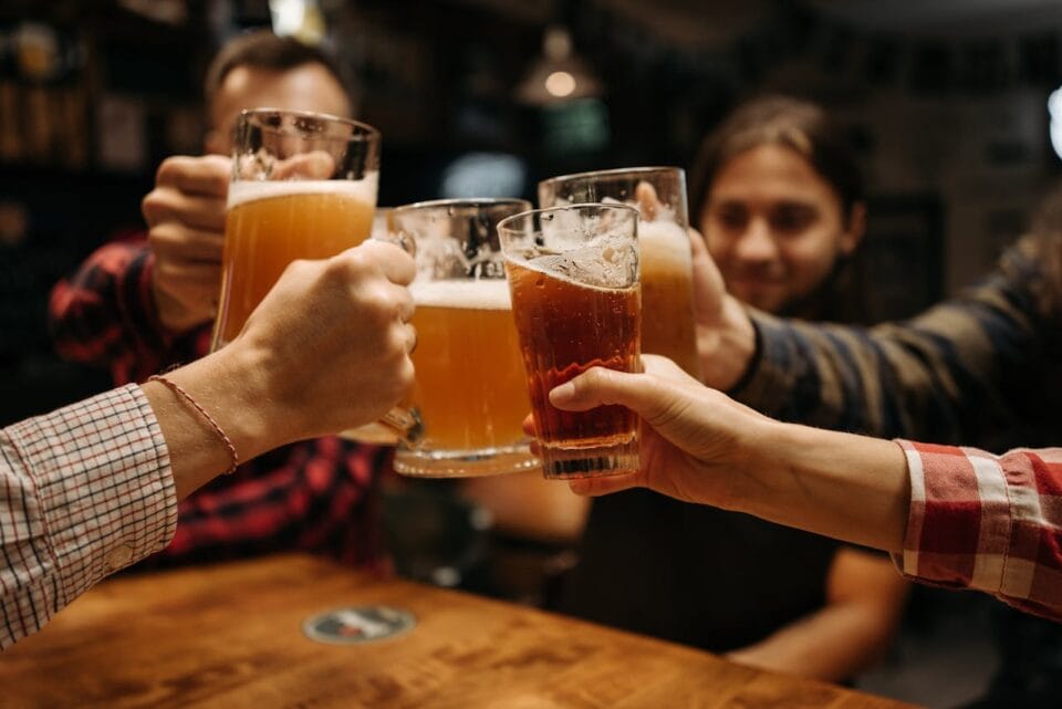 Amis trinquant avec des bières dans un bar