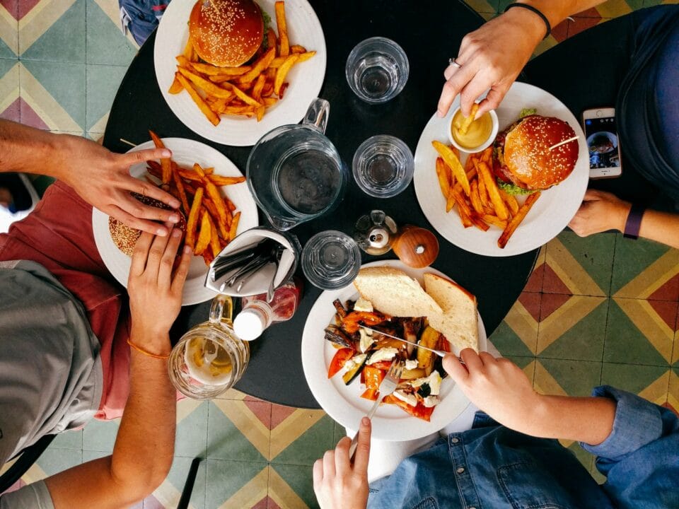 Amis partageant burgers et frites au restaurant