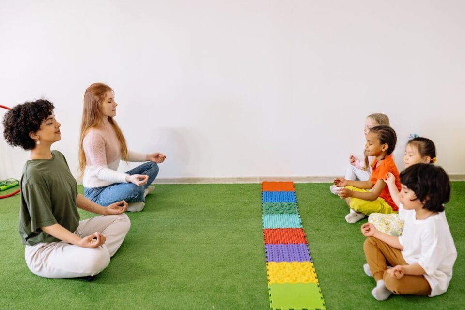 Enfants et adultes pratiquant la méditation en salle