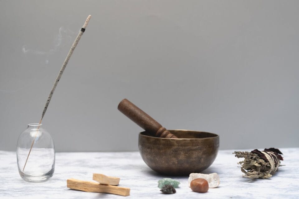 Encens, bol tibétain et pierres sur table