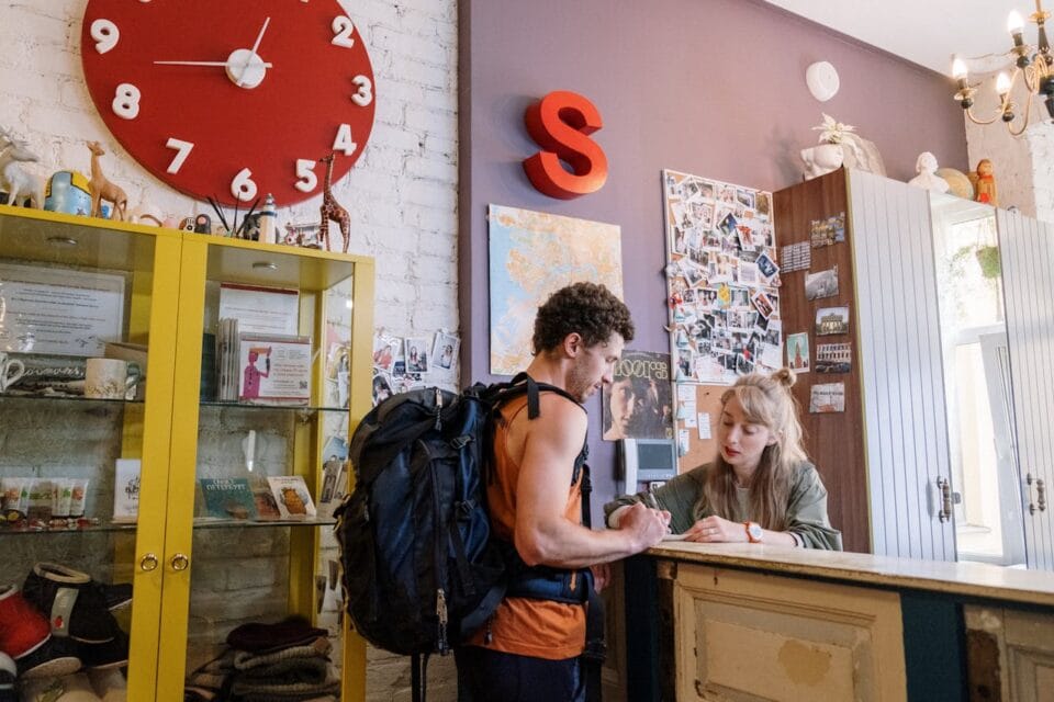 Accueil d'un backpacker à la réception de l'hôtel.