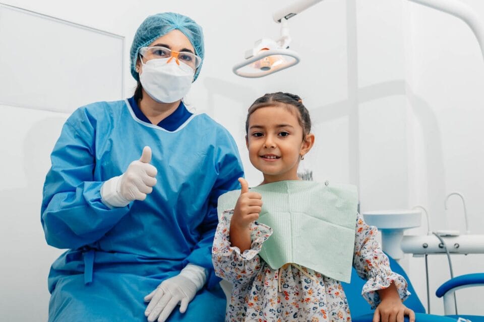 Une dentiste et une patiente font un signe ok de la main