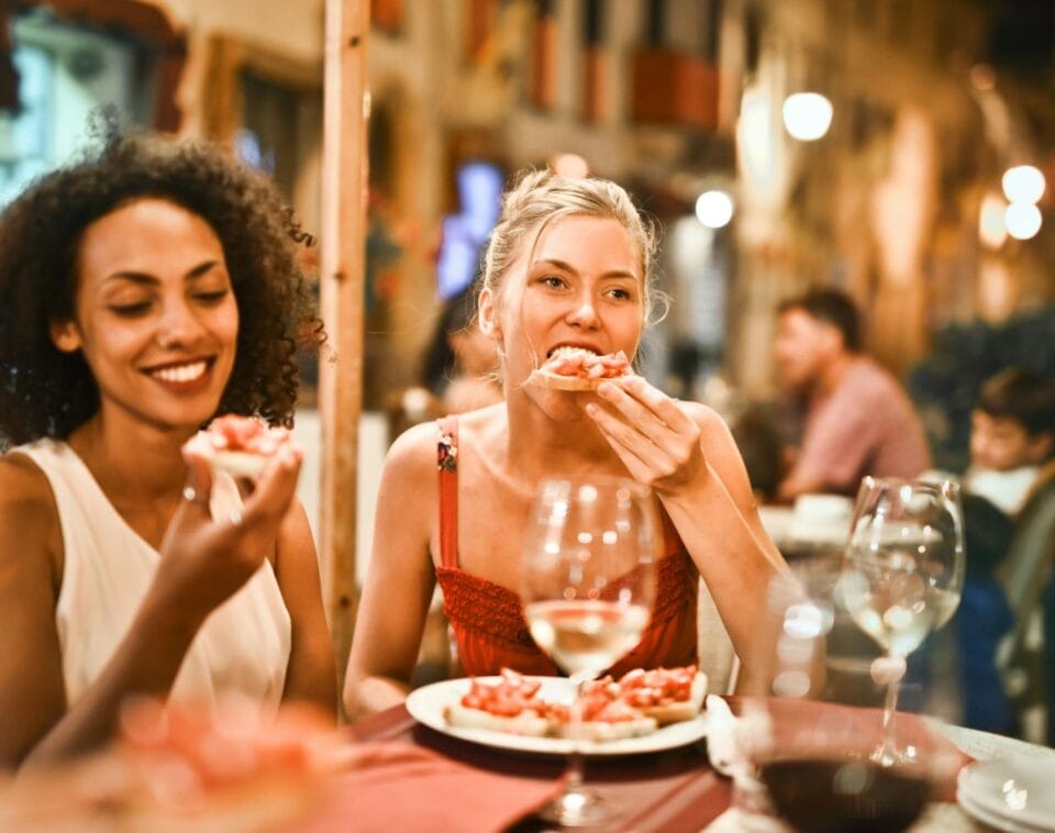 Deux femmes savourant une pizza en terrasse