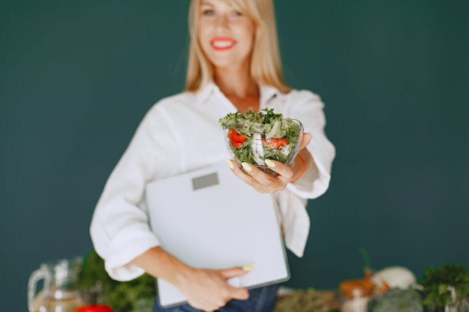 Nutritionniste tenant une salade fraîche et un classeur
