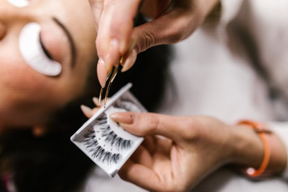 Esthéticienne appliquant des faux cils à une cliente