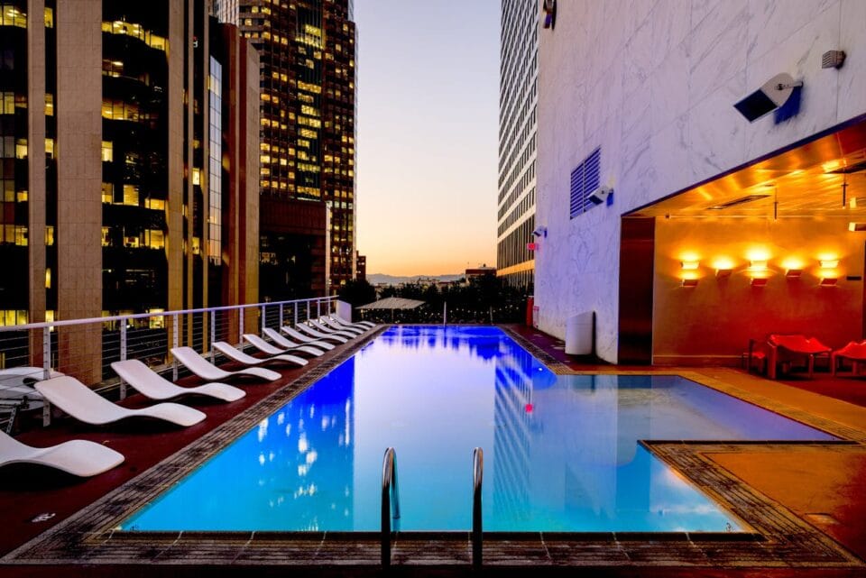Piscine sur toit, gratte-ciels, coucher de soleil urbain