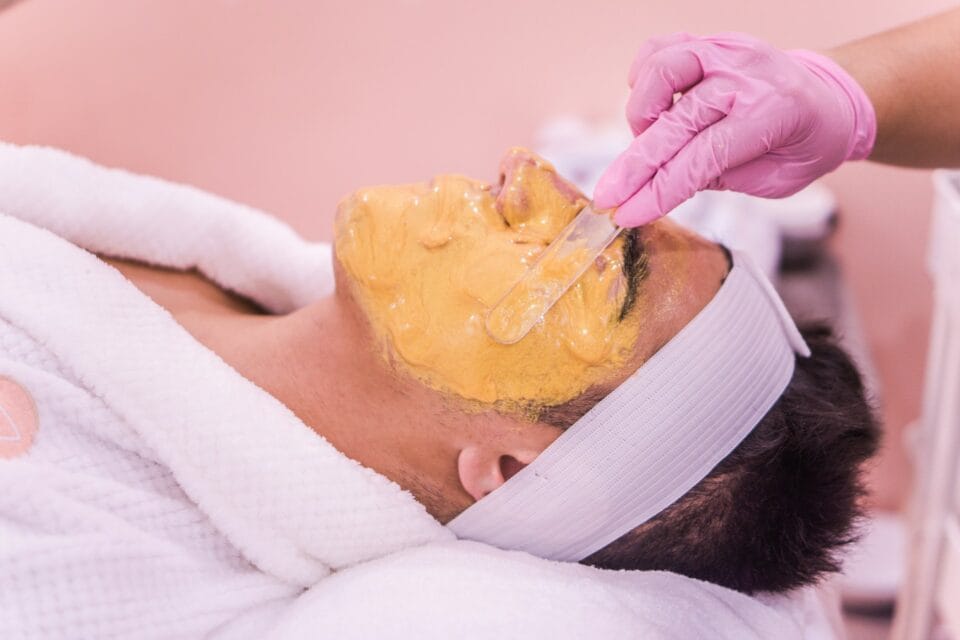 Application de masque facial doré en spa