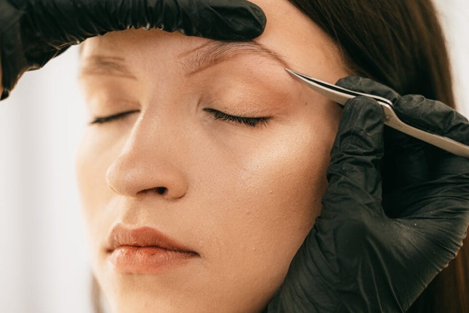 Femme recevant épilation sourcil en institut beauté