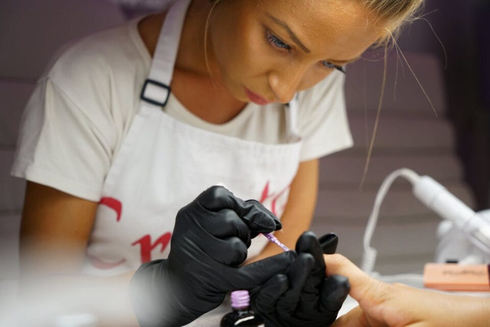 Manucure professionnelle appliquant du vernis à ongles