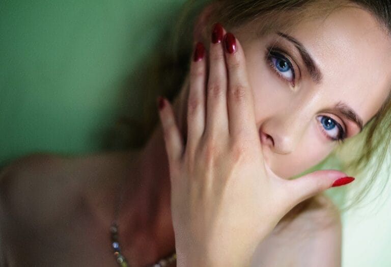 Femme avec ongles rouges et yeux bleus