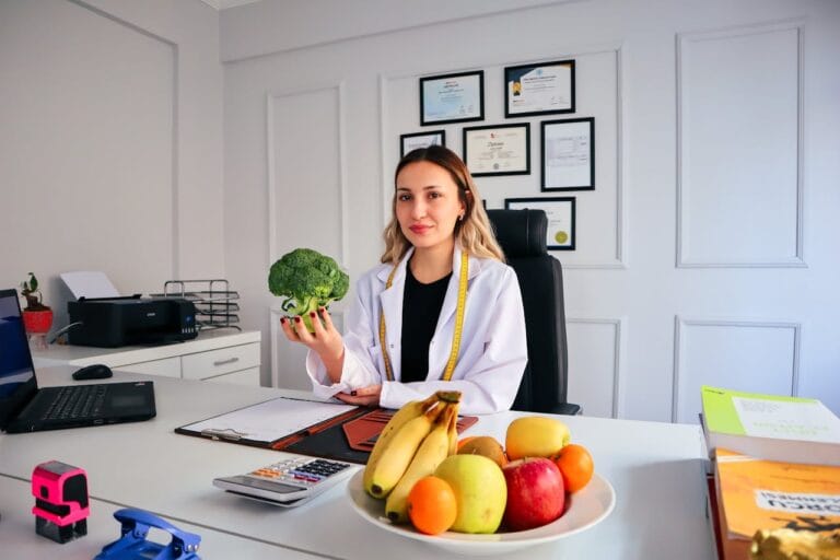 Nutritionniste avec brocoli et fruits au bureau