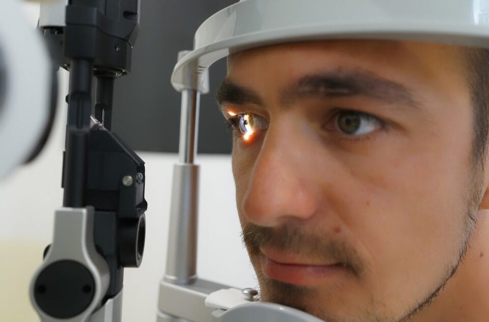 Homme utilisant un équipement d'examen oculaire