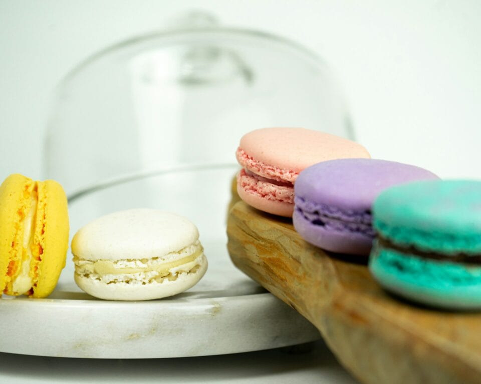 Macarons colorés sur plateau en bois, arrière-plan flou