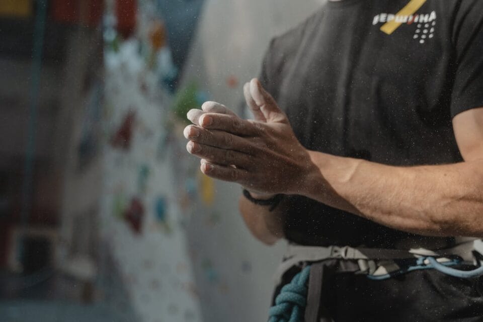Grimpeur préparant de la magnésie sur les mains