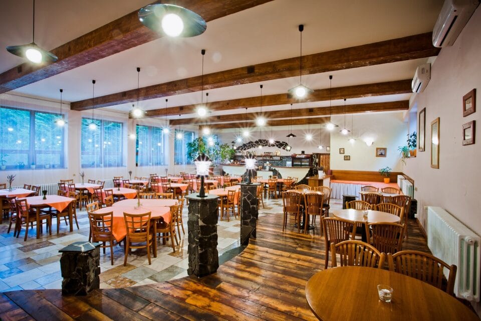 Restaurant intérieur, tables en bois, éclairage vif.