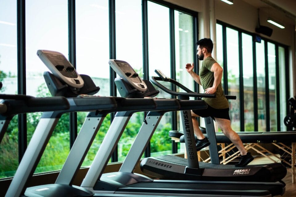 Homme courant sur tapis roulant dans salle de sport