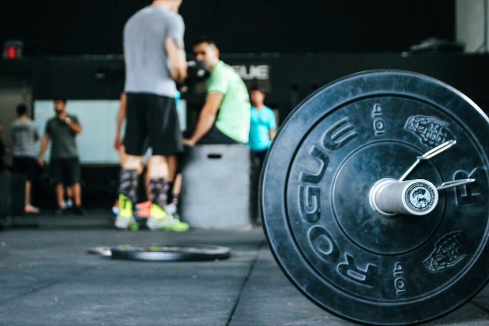 Hommes à la salle de sport discutant près d'haltères