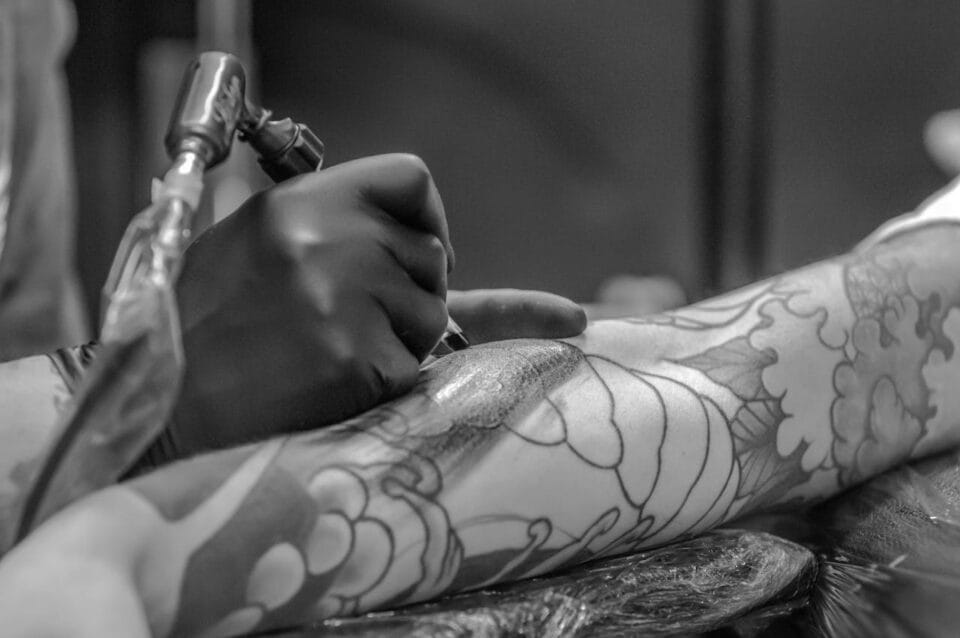 Tatouage artistique sur bras en noir et blanc