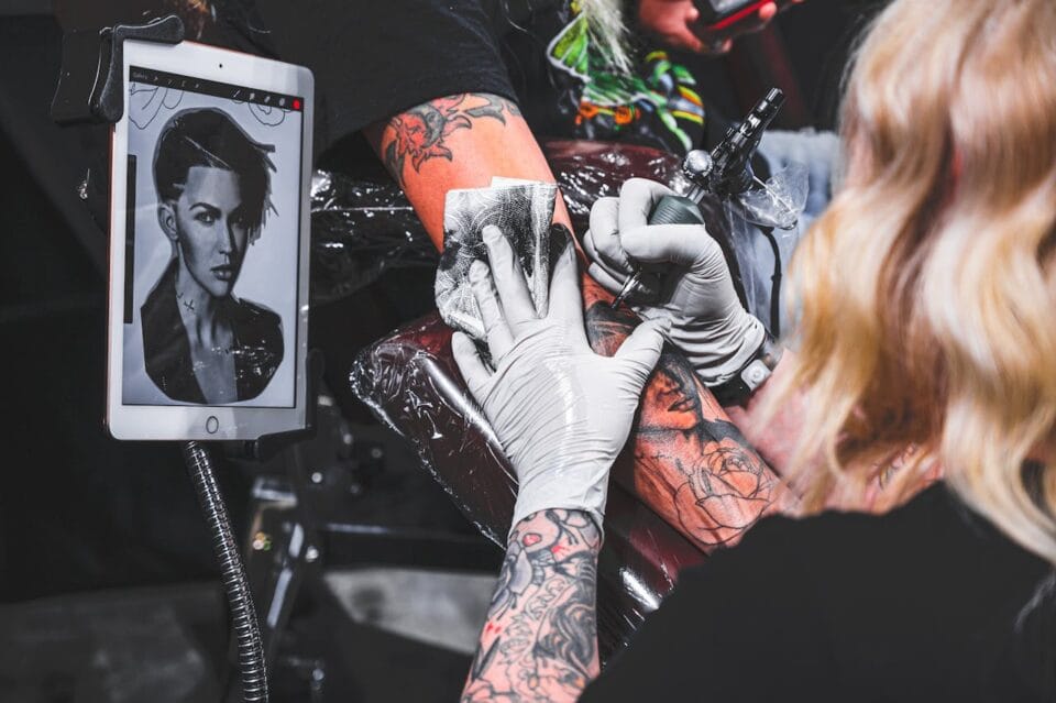 Tatoueur reproduisant portrait avec précision sur tablette