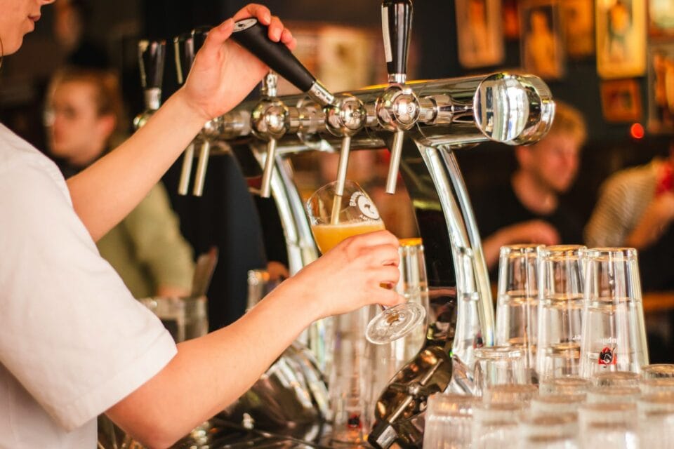 Barman servant une bière pression au bar.