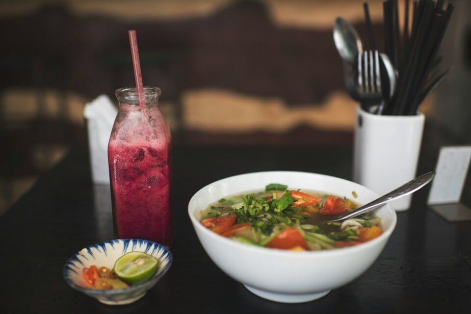 Soupe asiatique et boisson rouge en bouteille