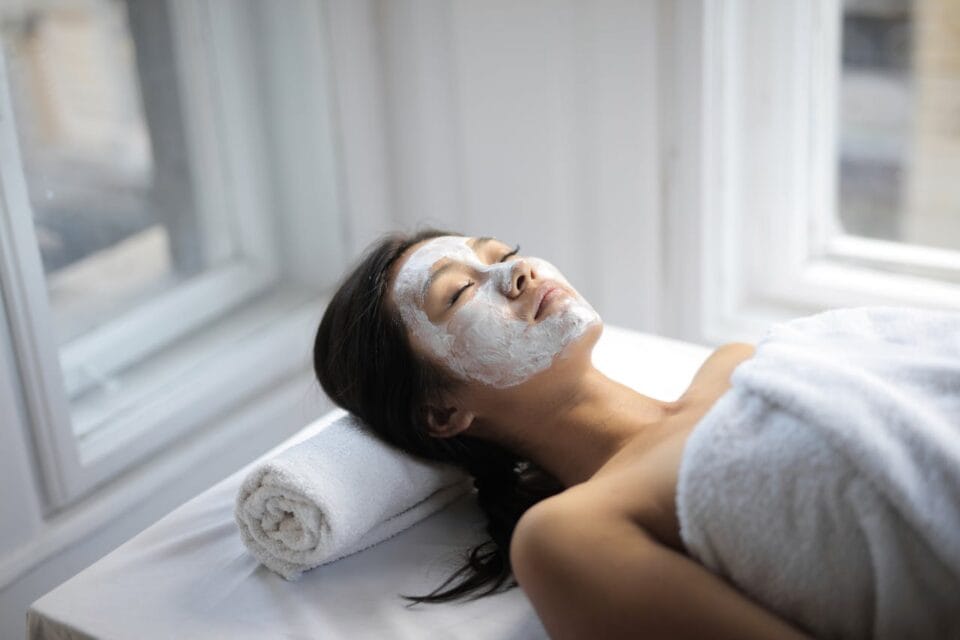 Femme détendue avec masque facial en spa