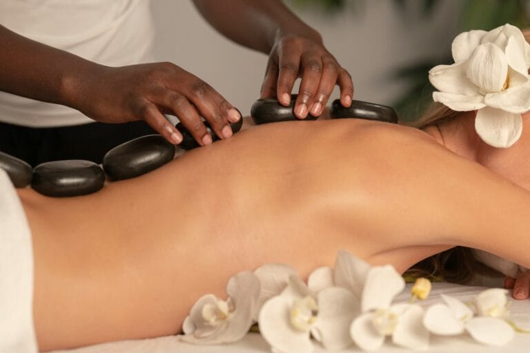 Massage aux pierres chaudes avec orchidées blanches