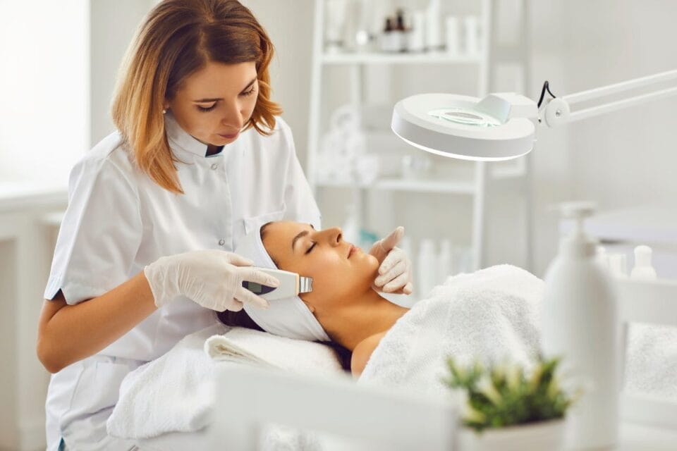 Esthéticienne traitant la peau d'une cliente au spa