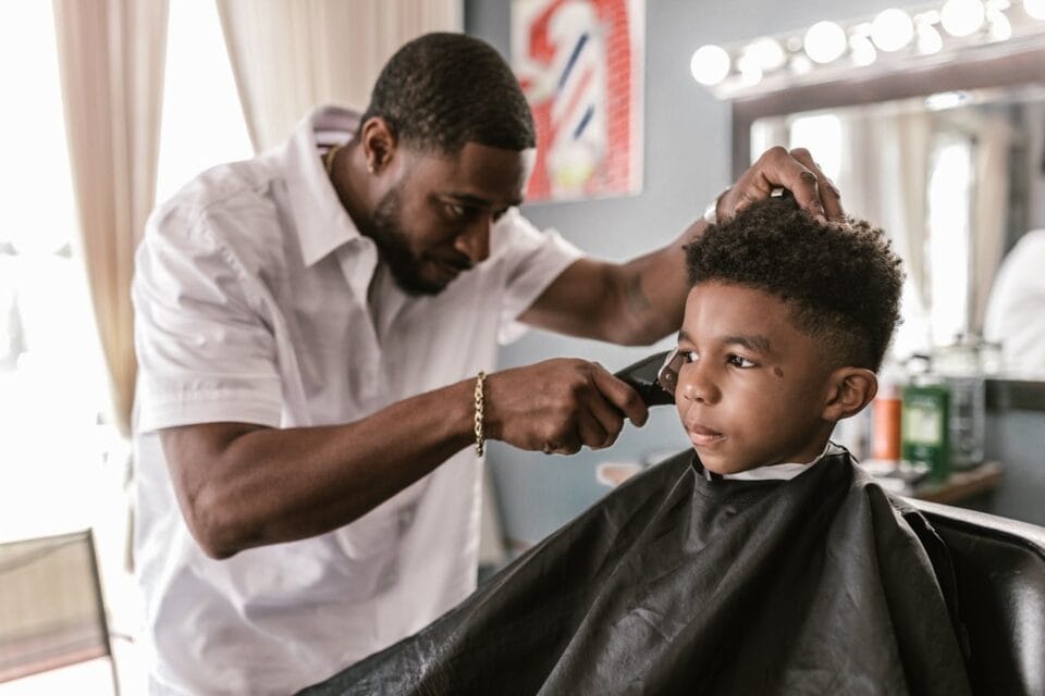 Barbier coupant les cheveux d'un jeune garçon
