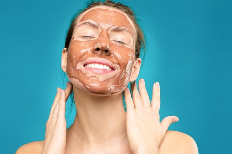 Femme appliquant un masque facial chocolat, fond turquoise